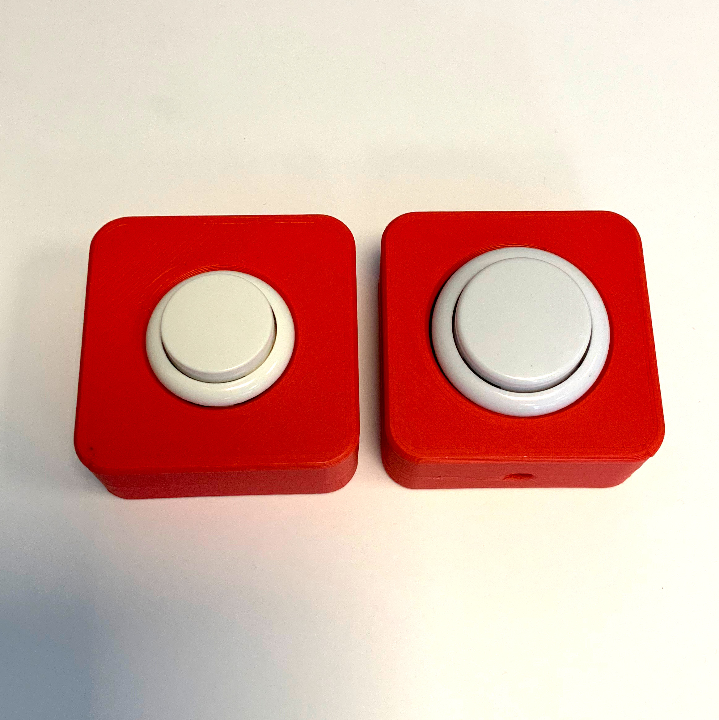 2 rote Buttons mit weißem Knopf. 24mm und 30mm Knopfdurchmesser.
