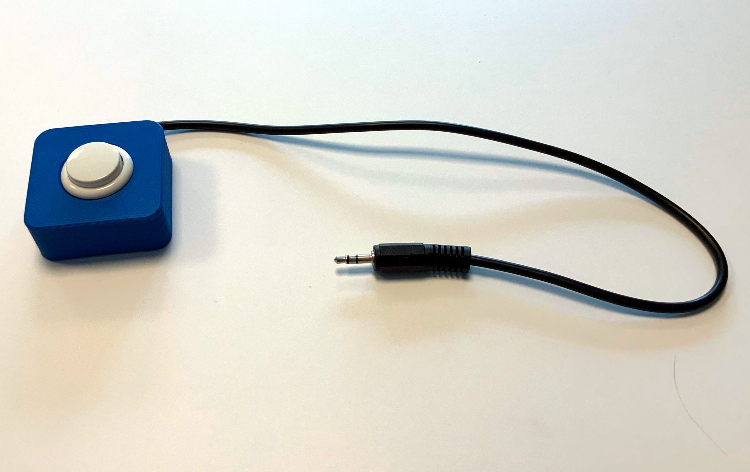 blaues Buttongehäuse mit weißem Knopf und 43cm Anschlusskabel mit 3.5mm Klinkenstecker